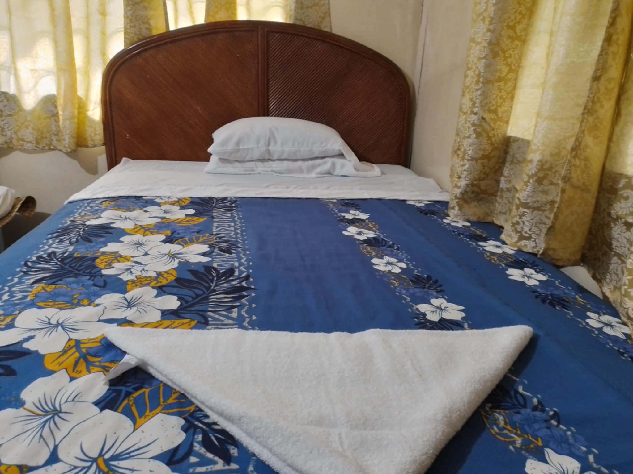 Guest room at Livingstone with blue floral bedding and a prepared towel