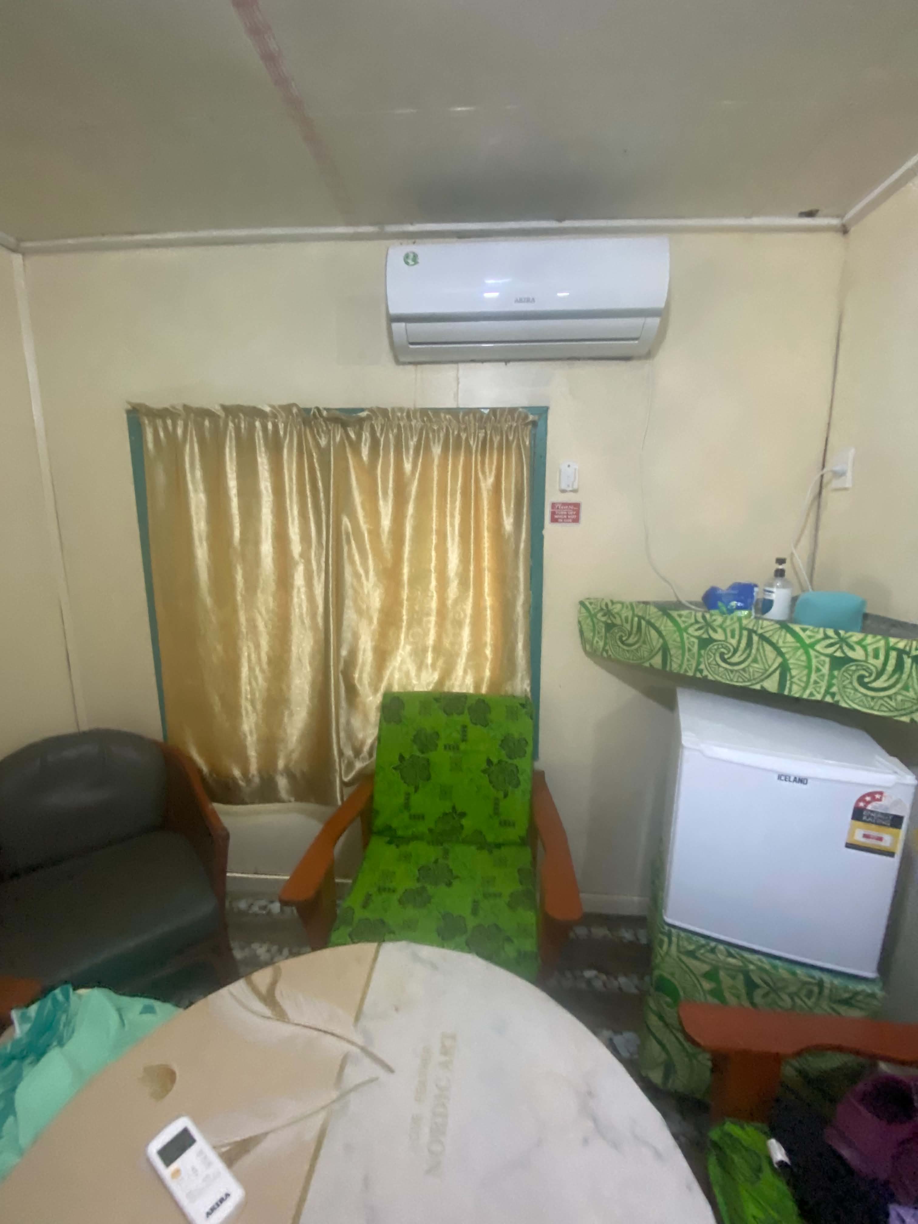 Guest living area with seating, air conditioning and a refrigerator